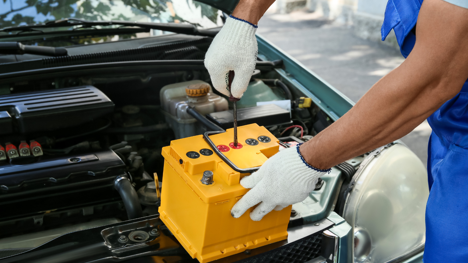 Mecânico removendo a bateria amarela de um carro